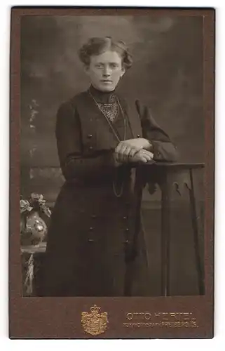 Fotografie Otto Hertel, Freiberg i. S., Dame in Sonntagsbekleidung mit Händen auf Tisch