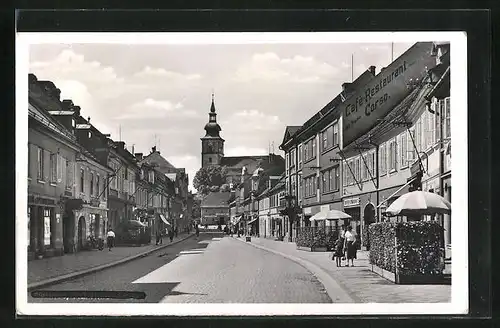 AK Niemes, Strassenpartie mit Geschäften und Blick zur Kirche