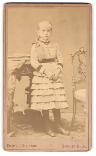 Fotografie Edmund Behncke, Schwerin i. M., Portrait blondes bildhübsches Mädchen im gerüschten Kleid