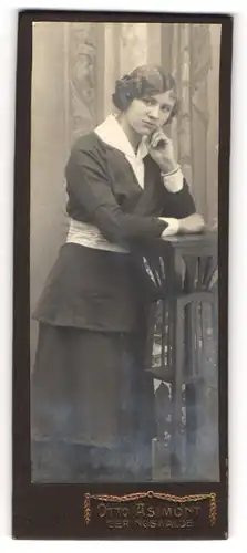 Fotografie Otto Asimont, Geringswalde, Portrait junge Dame in modischer Kleidung an Tisch gelehnt