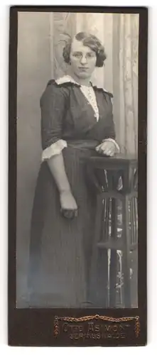 Fotografie Otto Asimont, Geringswalde, Portrait junge Dame in modischer Kleidung an Tisch gelehnt