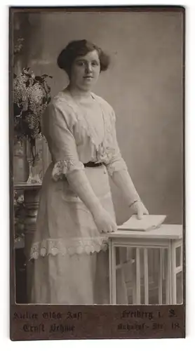 Fotografie Ernst Oehme, Freiberg i. S., Portrait bürgerliche Dame mit Buch an Tisch gelehnt