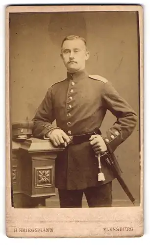 Fotografie H. Kriegsmann, Flensburg, Portrait Soldat in Uniform mit Zigarre