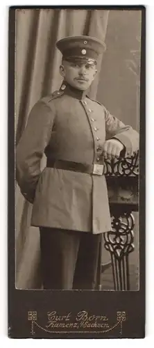 Fotografie Kurt Born, Kamenz i. S., Soldat in Uniform mit abgestützen Arm