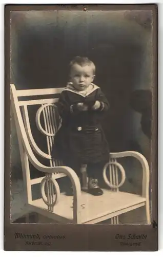 Fotografie Otto Schmidt, Wittmund, Portrait kleines Mädchen im Matrosenkleid auf Stuhl stehend