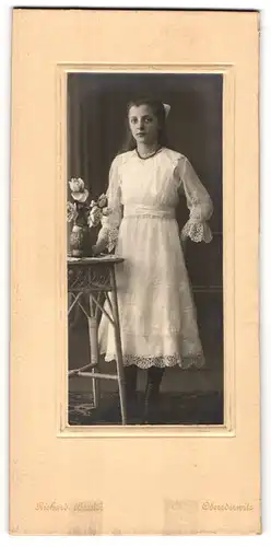 Fotografie Richard Bassler, Oberoderwitz, Hübsche Frau im weissen Kleid mit Hand auf Beistelltisch