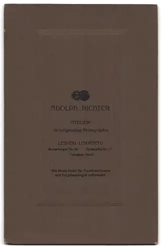 Fotografie Adolph Richter, Leipzig-Lindenau, Portrait weiss gekleidete Dame mit Zeitung an Tisch gelehnt