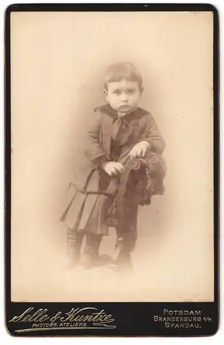 Fotografie Selle & Kunzte, Potsdam, Portrait modisch gekleidetes Mädchen auf Stuhl stehend