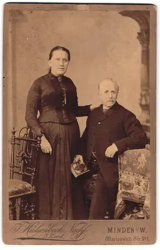 Fotografie J. Hülsenbeck Nachf., Minden i / W., Portrait älteres Paar in hübscher Kleidung mit Buch
