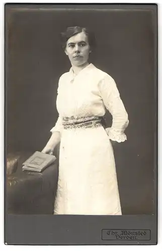 Fotografie Chr. Mönsted, Verden, Portrait weiss gekleidete Dame mit Medaillon und Buch