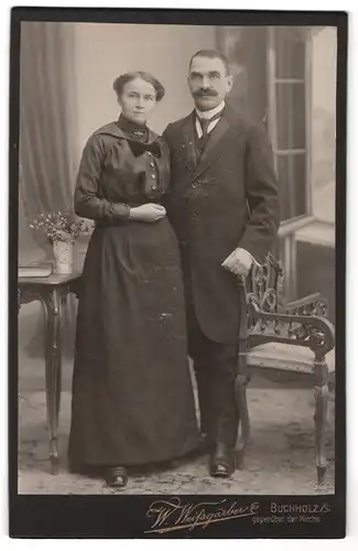 Fotografie W. Weissgärber, Buchholz / S, Portrait bürgerliches Paar in eleganter Kleidung am Stuhl