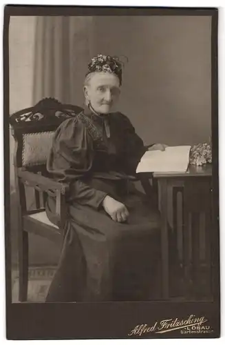 Fotografie Alfred Fritzsching, Löbau, Portrait ältere Dame im hübschen Kleid mit Haube und Buch