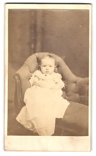 Fotografie P. H. Lakin, Montgomery, Ala., Portrait niedliches Kleinkind im weissen Kleid auf Sofa sitzend