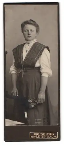 Fotografie Fr. Seidig, Oranienbaum, Portrait hübsch gekleidete Dame mit Kreuzkette und Blumen