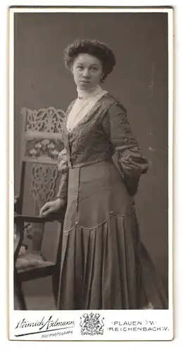 Fotografie Heinrich Axtmann, Plauen i. V., Portrait junge Dame in hübscher Kleidung an Stuhl gelehnt