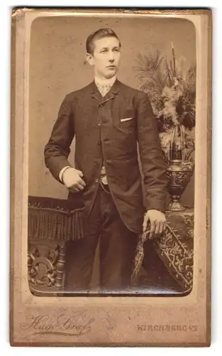 Fotografie Hugo Graf, Kirchberg i / S., Portrait modisch gekleideter Herr an Tisch gelehnt