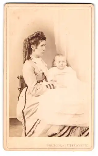 Fotografie Lutze & Witte, Magdeburg, Portrait Mutter mit eleganter Frisur und Baby im Arm