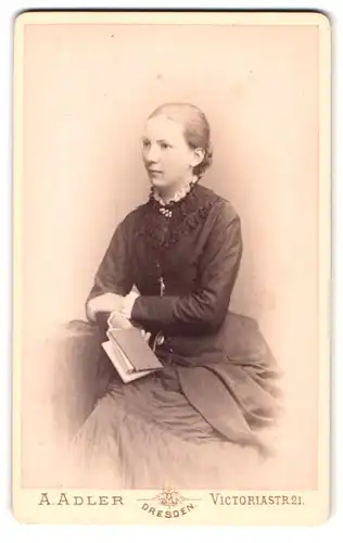 Fotografie A. Adler, Dresden, Portrait junge Frau in dunklen Kleid mit Büchlein in Händen