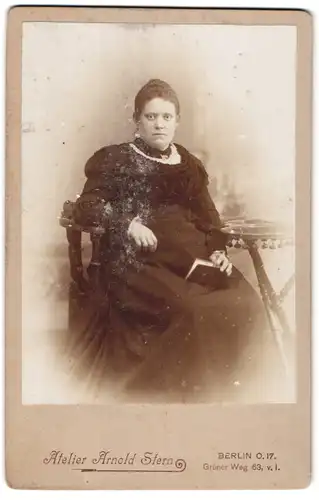 Fotografie Arnold Stern, Berlin-O, Portrait bürgerliche Dame mit Buch am Tisch sitzend