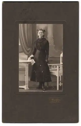 Fotografie F. Wallbröhl, Bochum-Hamme, Portrait schwarz gekleidete Dame mit Buch an Tisch gelehnt