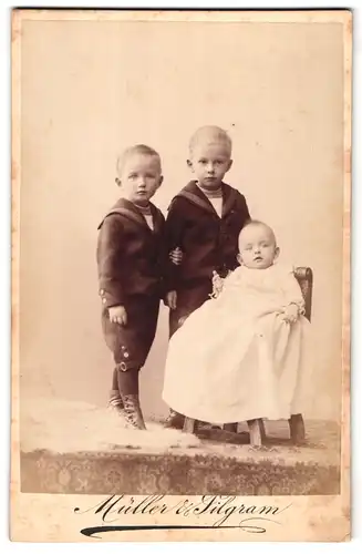 Fotografie Müller & Pilgram, Magdeburg, Portrait von zwei kleinen Jungen in Matrosenanzügen mit einem Baby