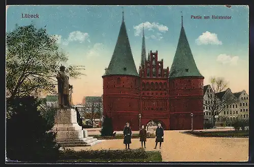 AK Lübeck, Passanten am Denkmal vor dem Holstentor