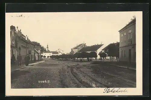 AK Dobrís, Blick in eine Strasse mit Kirche