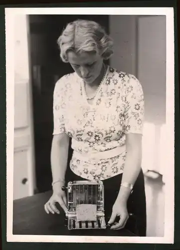 Fotografie Junge Dame präsentiert elektrischen Brotröster, Toaster