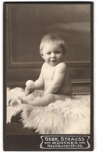 Fotografie Gebr. Strauss, München, Portrait Kind auf einem Fell posierend
