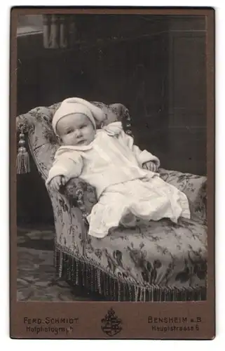 Fotografie Ferd. Schmidt, Bensheim a. B., Portrait eines Kleinkindes entspannt auf einem Sessel sitzend