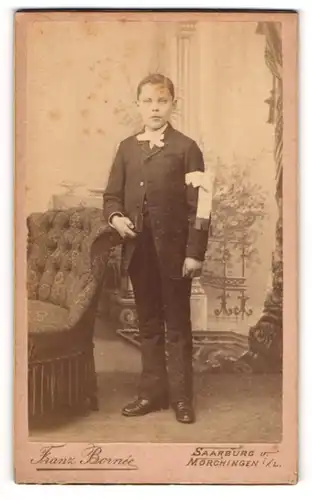 Fotografie Franz Bornée, Saarburg i. Loth., junger französischer Knabe zur Kommunion im Anzug mit Armschleife