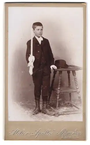 Fotografie Atelier Apollo, München, Steinstr. 12, junger bayrischer Knabe im Anzug mit Kerze und Hut, Kommunion