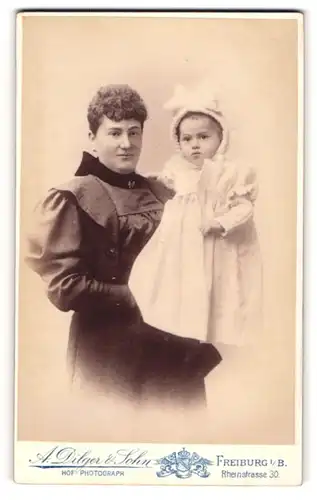 Fotografie A. Dilger & Sohn, Freiburg i. B., Mutter im dunklen Kleid mit ihrer Tochter im weissen Kleid auf dem Arm