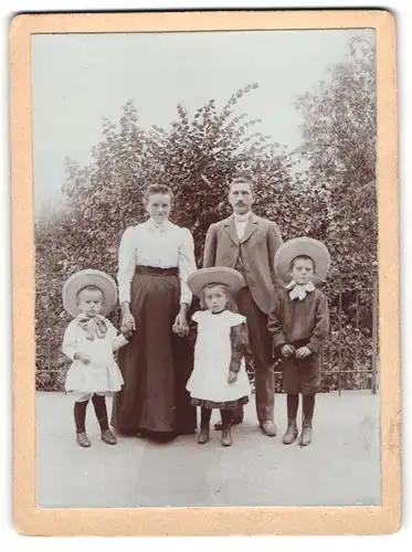 Fotografie unbekannter Fotograf und Ort, Mutter und Vater mit ihren drei Kindern in Sommerkleidern, Mutterglück
