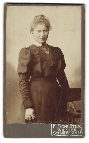 Fotografie F. Schlüter, Wilster, Portrait junge Dame im eleganten Kleid an Stuhl gelehnt