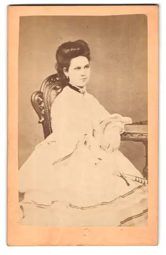 Fotografie unbekannter Fotograf und Ort, Portrait elegant gekleidete Dame mit Buch am Tisch sitzend