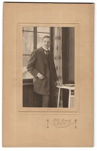 Fotografie Alb. Grund, Ohligs, Mann im Anzug mit Hand auf Tisch