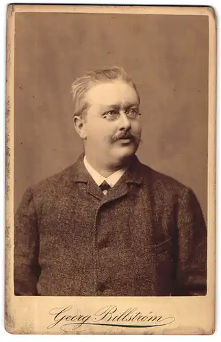 Fotografie Georg Billström, Kiel, Älterer Mann im Anzug mit Oberlippenbart und Brille