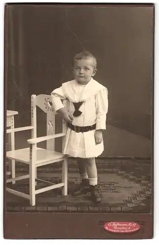 Fotografie E. Hoffmann Nachf., Dresden, Portrait hübsch gekleidetes Mädchen an Stuhl gelehnt
