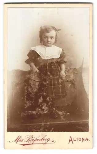 Fotografie Max Reisenberg, Hamburg-Altona, Portrait süsses kleines Mädchen mit Haarschleife und Eimer in der Hand