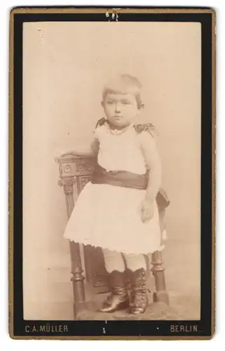 Fotografie C. A. Müller, Berlin-N, Chaussee-Strasse 40, Portrait kleines Mädchen im weissen Kleid auf Stuhl stehend