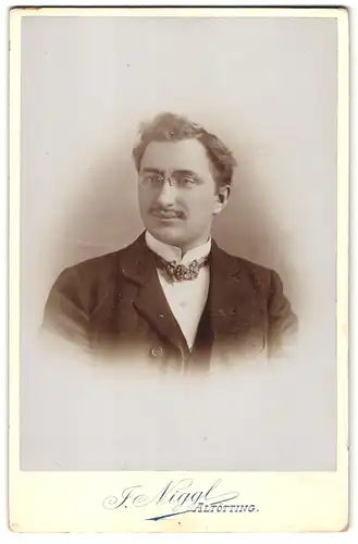 Fotografie F. Niggl, Altötting, Portrait eines jungen Herren mit Nickelbrille und leicht gelocktem Haar