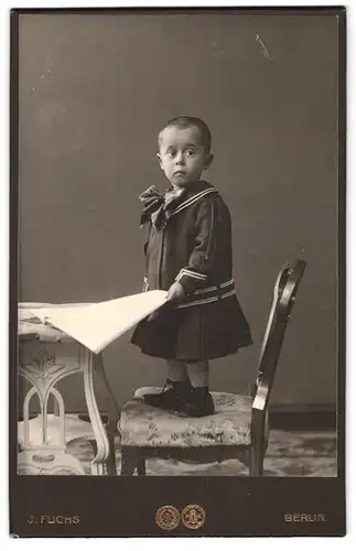 Fotografie J. Fuchs, Berlin-N, Friedrichstr. 108, Portrait kleines Mädchen im Matrosenkleid mit Zeitung