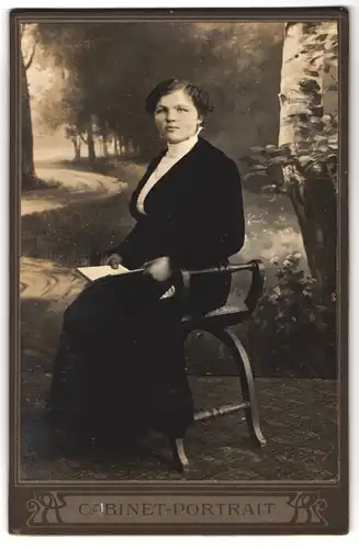 Fotografie Cabinet-Portrait, Ort unbekannt, Portrait bürgerliche Dame mit Buch auf Hocker sitzend