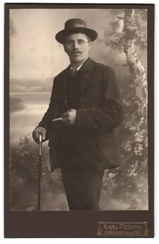 Fotografie Karl Perino, Deggendorf, Graben 273 1 /2, Portrait elegant gekleideter Herr mit Hut, Stock und Zigarre