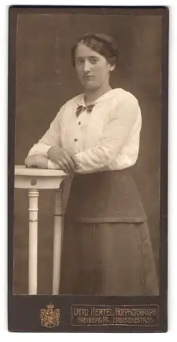 Fotografie Otto Hertel, Freiberg i / S., Erbische-Str. 11, Portrait junge Dame in weisser Bluse an Tisch gelehnt