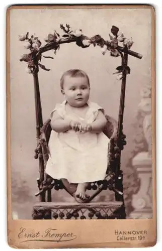 Fotografie Ernst Tremper, Hannover, Cellerstr. 19a, Portrait kleines Mädchen im weissen Kleidchen im Hochstuhl sitzend