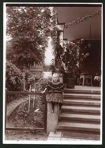 Fotografie Ansicht Güstrow, Kind posiert auf Treppe von August Haackert