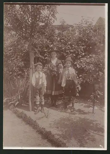 Fotografie Ansicht Güstrow, Kinder und Frau in Tracht posieren am Haus von August Haackert