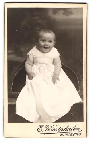 Fotografie E. Westphalen, Bamberg, Portrait niedliches Baby im langen weissen Kleid